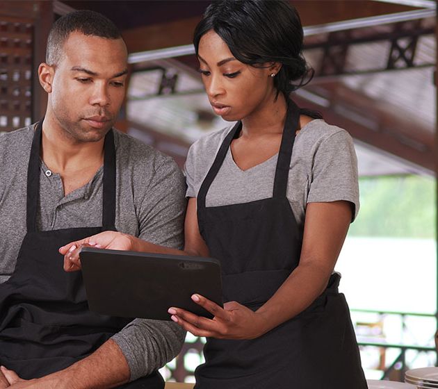 Restaurant employees looking over sales reporting tools from North