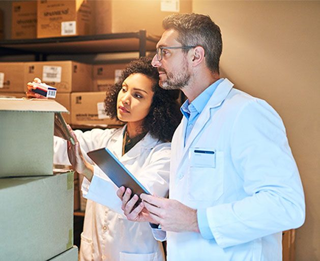 Two healthcare professionals taking inventory of stock with a tablet