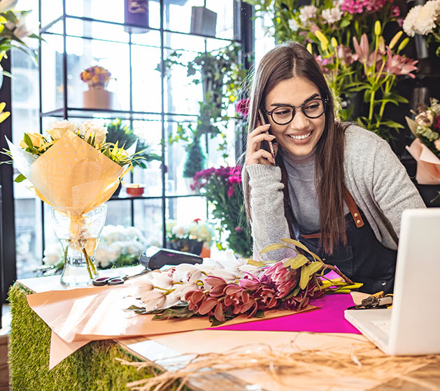 A florist smiling at how streamlined her business operations are thanks to North's POS systems