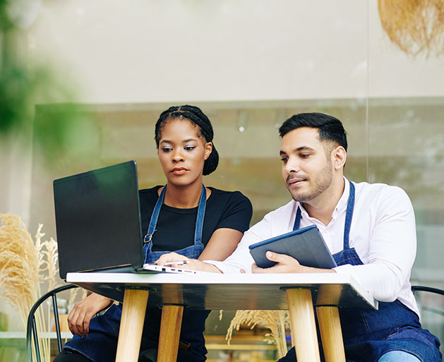 Restaurant employees looking over sales reporting tools from North