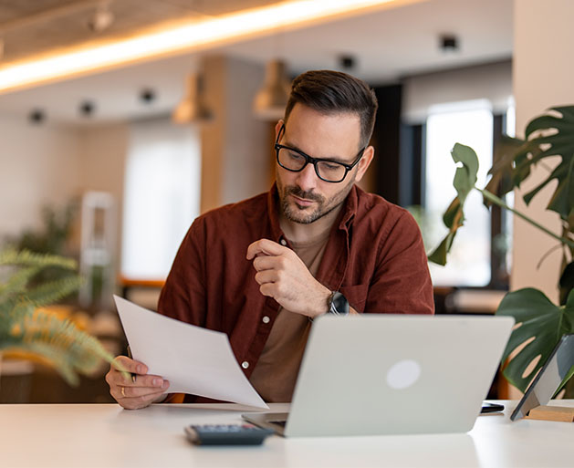 A business owner reviewing paper invoice reports built using North's POS systems